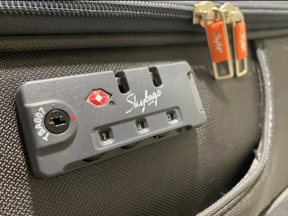 قفل حقيبة سفر بتقنية TSA مع سحابات مغلقة، يوضح أفضل طريقة لحماية الأمتعة أثناء السفر