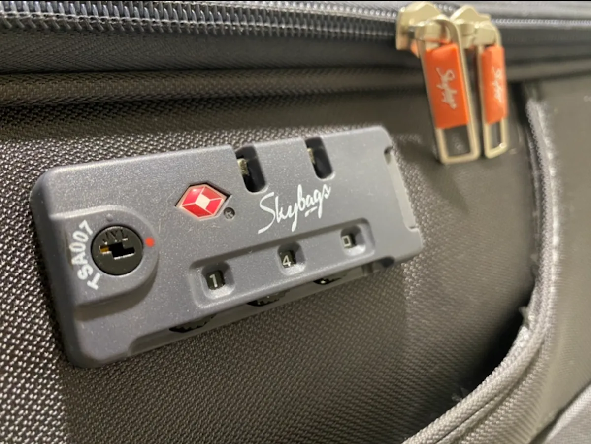 قفل حقيبة سفر بتقنية TSA مع سحابات مغلقة، يوضح أفضل طريقة لحماية الأمتعة أثناء السفر