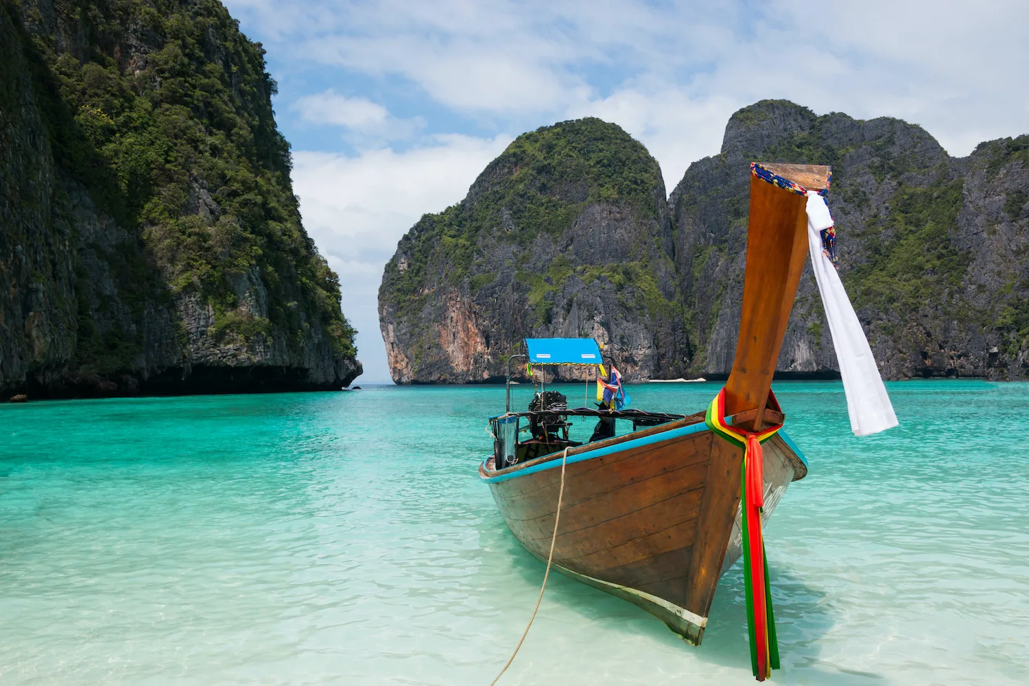 خليج مايا الشهير في تايلند مع قوارب تقليدية على مياه زرقاء صافية