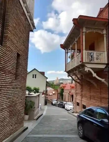 زقاق تقليدي في المدينة القديمة بتبليسي، مع شرفات خشبية ومباني تاريخية على الطراز الجورجي