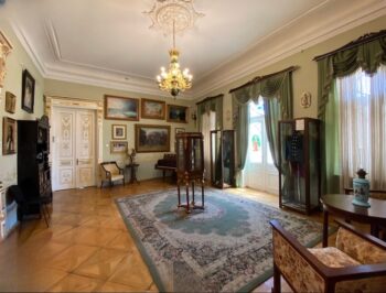 غرفة فنية داخل قصر الفن في تبليسي مزينة بلوحات كلاسيكية وأثاث فاخر يعكس الطراز الجورجي