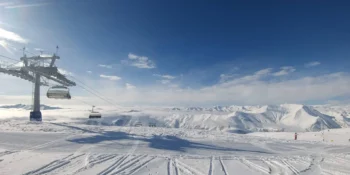 منتجع غودوري في جورجيا يظهر جبال القوقاز والتلفريك ومنحدرات التزلج