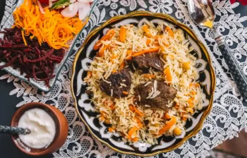 طبق البيلاف من المطبخ الأذربيجاني التقليدي بالأرز واللحم والجزر يُقدَّم مع اللبن والسلطات الجانبية