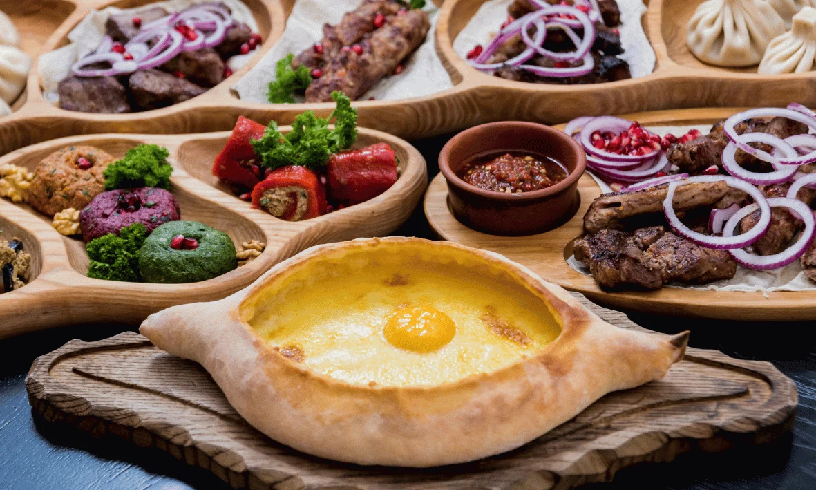 مائدة جورجية تقليدية تضم خاتشابوري وخينكالي ولحوم مشوية ومقبلات متنوعة