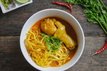 طبق Khao Soi التايلندي التقليدي بشوربة الكاري الحمراء مع الدجاج والنودلز من المطبخ التايلندي في شمال تايلند