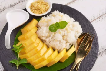 طبق Mango Sticky Rice التايلندي مع شرائح المانجو والأرز اللزج وصلصة حليب جوز الهند
