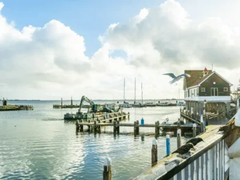 قرية ساحلية في هولندا خلال فصل الصيف مع قوارب صغيرة وأجواء مشمسة على الواجهة البحرية