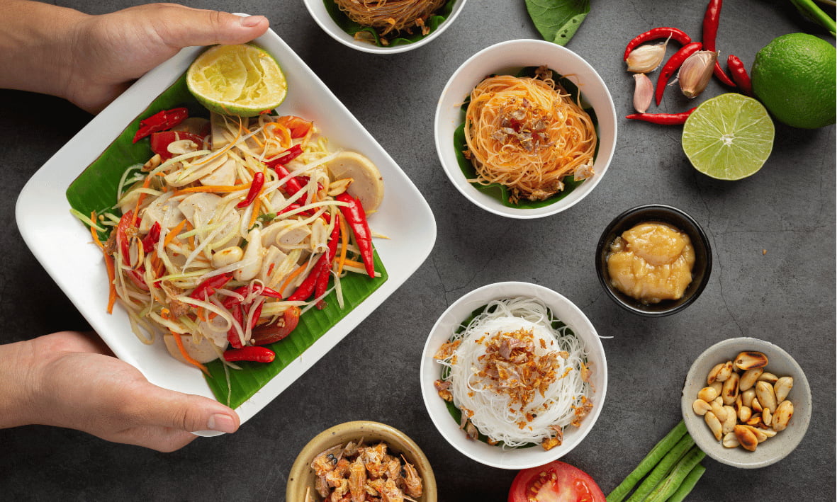 مجموعة من الأطباق التايلندية التقليدية على طاولة منزلية تعكس تنوع النكهات الإقليمية وتجربة الطعام في تايلند