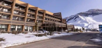 واجهة فندق Shahdag Hotel & Spa في منتجع شاهداغ بأذربيجان مع إطلالة على جبال مغطاة بالثلوج